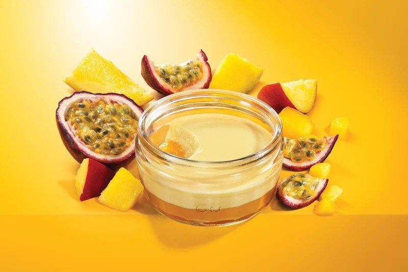 Gü mango and passion fruit dessert in a glass ramekin with cut fruit
