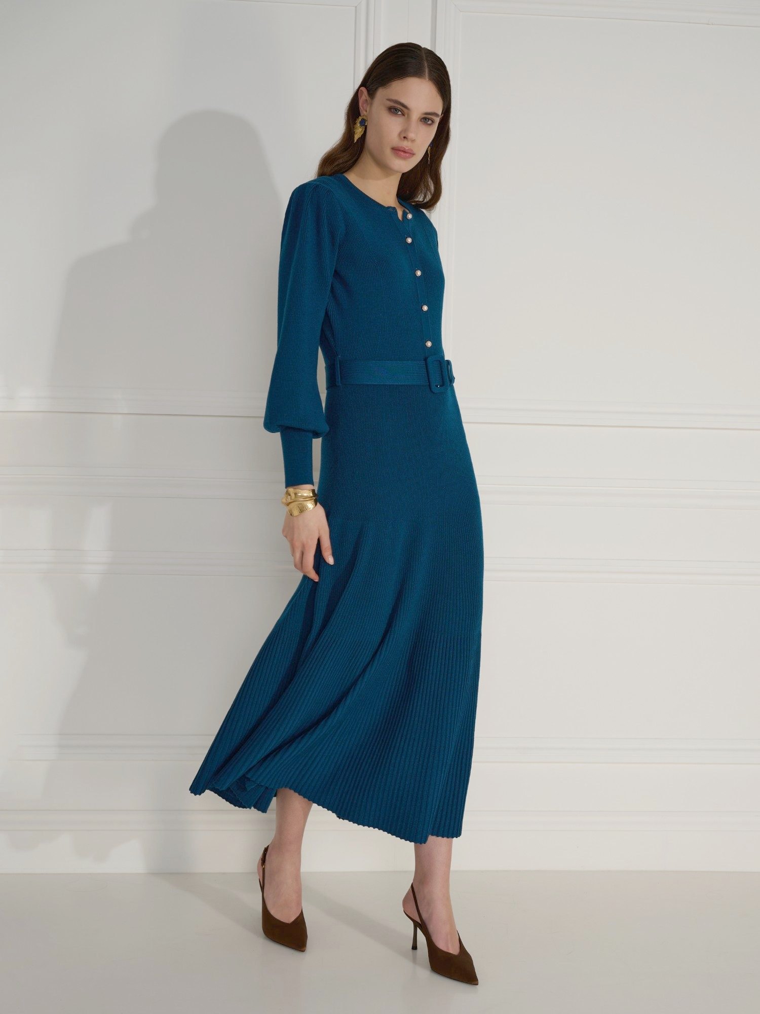 Model in a teal knit dress shot against a panelled wall backdrop hired from Motherlight Studios