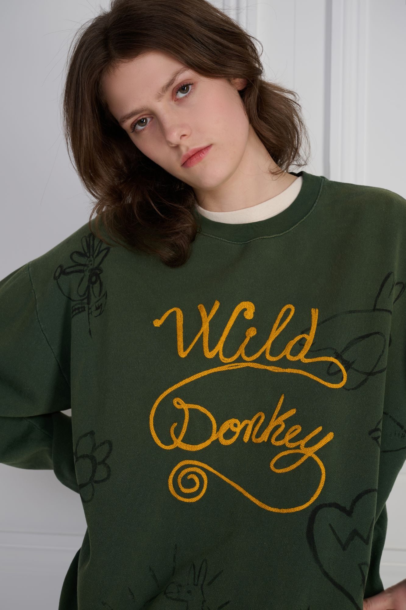 Wild Donkey green sweatshirt with chain-stitch embroidery on model